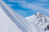 Professional snowboarder Helen Schettini, rides fresh powder on a sunny day while snowboarding in Haines, Alaska.