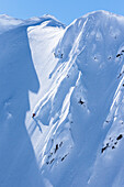 Professional snowboarder Marie France Roy, rides fresh powder on a sunny day while snowboarding in Haines, Alaska.