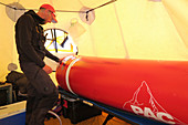 Ein Mountain Ranger und Sanitäter pumpt Luft in eine tragbare Höhenkammer im Medical Camp auf Denali