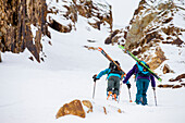Two friends backcountry skiing on snowy landscape in the Wasatch Mountains