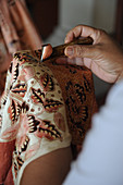Indonesia, Bali, Celuk, Batik Manufacturing, The technique consists in drawing a pattern on a fabric, protecting the fabric against staining by an application of hot wax, then applying the color by soaking in dye bath