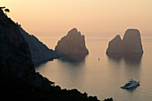 Italy, Amalfi Coast, Capri, Sunset on the Faraglioni. The Faraglioni are Capri's 3 mythical rocks. Seen from the Marina Piccola