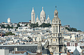 France. Paris 9th district. Bell tower of the Sainte Trinité church and the Sacre-Cœur Basilica