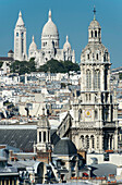 France. Paris 9th district. Bell tower of the Sainte Trinité church and the Sacre-Cœur Basilica