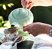 Pouring tea at Ludham village tearoom. Norfolk broads England UK.