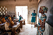 A female teacher teaching at the front of the classroom at a primary school in Ghana, West Africa, Africa