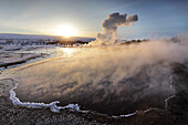 Heiße Pools und Dampf von Strokkur Geysir bei Sonnenaufgang, Winter, im geothermalen Bereich neben dem Fluss Hvita, Geysir, Island, Polarregionen