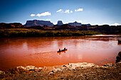 Canoeing the Colorado RIver after heavy rainstorms have turned the river deep red, Canyonlands National Park, Utah