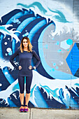 Portrait of athletic woman standing against street art, Boston, Massachusetts, USA