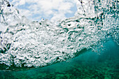Eine Welle wird gesehen, die von Unterwasser auf einem Abschnitt von Glover's Reef, Belize bricht.