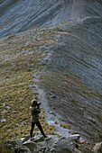 Person standing on rocks and photographing Nevado de Toluca landscape, Toluca, State of Mexico, Mexico