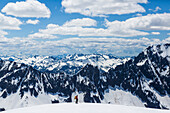 Skifahrer gegen majestätische Landschaft von schneebedeckten Bergen, Nordkaskaden-Nationalpark, Washington State, USA.