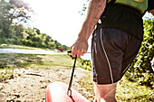 Rear view shot of man carrying sea kayak, Portland, Maine, USA