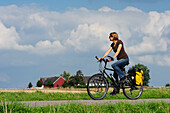 Woman on bicycle on the island of Ven, Skane, Southern Sweden, Sweden