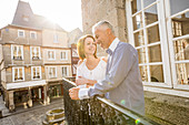 Caucasian couple smiling on balcony in city
