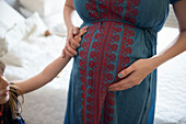 Caucasian girl feeling belly of expectant mother