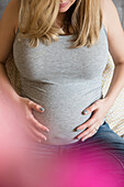 Caucasian expectant mother holding belly