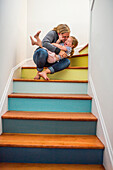 Caucasian mother kissing daughter on staircase