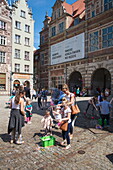Children enjoy playing with giant soap bubbles in Old Town, Gdansk, Pomerania, Poland