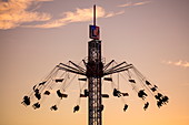 '80 meter tall amusement ride ''Flyer'' during Lullusfest carnival celebration at sunset, Bad Hersfeld, Hesse, Germany'