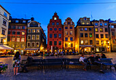 Menschen sitzen auf Parkbänke auf dem Hauptplatz Stortorget  in der Altstadt Gamla Stan , Stockholm, Schweden