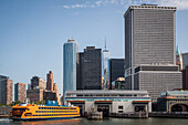 staten island ferry coming into the battery park boat terminal with a view of one world trade center and the financial district, new york harbor, new york city, state of new york, united states, usa