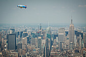 blimp for the japanese fujifilm company flying over the empire state building, midtown, manhattan, new york city, state of new york, united states, usa