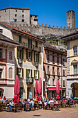 restaurant and cafe terraces on a square in the old town of bellinzona at the foot of castelgrande castle, listed as a world heritage site by unesco, bellinzona, canton of ticino, switzerland