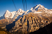 view from the cabin of the cable car linking birg to murren with the summits of the eiger, the monch and the jungfrau, jungfrau region, bernese alps, canton of berne, switzerland