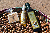 soap, argan cosmetic and cooking oil in a basket of argans, the women's cooperative of marjana, traditional manufacturing of argan oil and cosmetics,  essaouira, mogador, atlantic ocean, morocco, africa