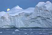 after the sunset, the moon rising over the icebergs in the ice fjord, jakobshavn glacier, 65 kilometres long, coming from the inlandsis, sermeq kujalleq, ilulissat, greenland