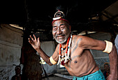 Smiling Naga man, headhunter, Wokshing Pensha, doing playful tribal dance, wearing Naga necklaces and elephant tusk arm bands, Nagaland, India, Asia