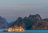 Vietnam, Ha Long Bay, cruise boat at sunset (UNESCO World Heritage)