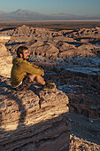 Happy hiker enjoying the view at sunset across Death Valley, near San Pedro de Atacama, Chile, South America