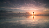 Silhouette woman at sea shore against cloudy sky during sunset, Daytona, Florida, USA