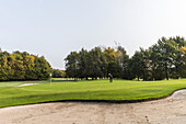 golf player and sand bunker on a golf course near Hamburg, north Germany, Germany
