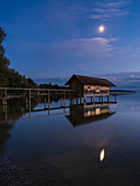 Mond über dem Bootshaus bei Stegen am Ammersee, Bayern, Deutschland