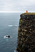 tiny lighthouse on the steep cliffs, southcoast, Iceland