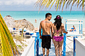 Kubanisches Pärchen läuft zum Strand. Tattoo auf Rücken Revolucion, Symbol Kuba, Touristen am schönsten Strand von Cayo Guillermo, Playa Pilar, einer der 10 schönsten Strände der Karibik, Pauschalurlaub, feiner Sand, Sandstrand, Strand, türkisblaues Meer,