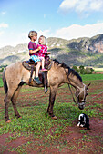 Small children on a horse, horseride, Mogotes and tobacco fields in Vinales, climbing region, loneliness, countryside, beautiful nature, family travel to Cuba, parental leave, holiday, time-out, adventure, MR, National Park Vinales, Vinales, Pinar del Rio