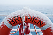 Mit Schnee bedeckter Rettungsring an Bord von Expeditions-Kreuzfahrtschiff MS Bremen (Hapag-Lloyd Cruises) während der Antarktis-Umrundung von Ushuaia in Argentinien nach Bluff in Neuseeland, Rossmeer, Antarktis