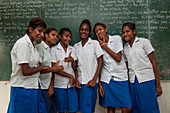 Schoolgirls line up in front of the chalkboard at school, Ambrym Island, Vanuatu, South Pacific