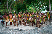 A group of dancers in traditional costume gather inside a circle of stones, Nendo Island, Santa Cruz Islands, Solomon Islands, South Pacific