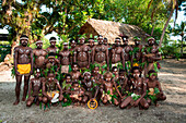 A group of men and boys wearing traditional garb and some with pan flutes gather before performing a dance during a cultural performance, Arabala, Langa Langa Lagoon, Malaita, Solomon Islands, South Pacific