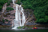 Passagiere von Expeditions-Kreuzfahrtschiff MS Bremen (Hapag-Lloyd Cruises) fahren mit Zodiac Schlauchboot und fotografieren einen Wasserfall, der über eine Platte des Felsens läuft, Misty Fjords National Monument, Tongass National Forest, Alaska, USA, No