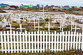 White crosses are enclosed by a white picket fence in this cemetery, Sisimiut, Qeqqata, Greenland
