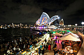 The lit-up Opera House with Opera Bar during the Vivid Festival, Sydney, New South Wales, Australia