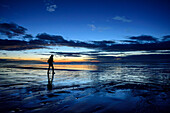 Frau wandert in der Dämmerung über Strand, Tasmanische See, Hump Ridge, Hump Ridge Track, Fiordlands Nationalpark, UNESCO Welterbe Te Wahipounamu, Southland, Südinsel, Neuseeland
