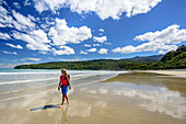 Woman hiking on beach, Tasman Sea, Hump Ridge, Hump Ridge Track, Fiordlands National Park, UNESCO world heritage Te Wahipounamu, Southland, South island, New Zealand