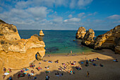 Badegäste am Strand zwischen steilen Felsen, Praia do Camilo, Lagos, Algarve, Portugal